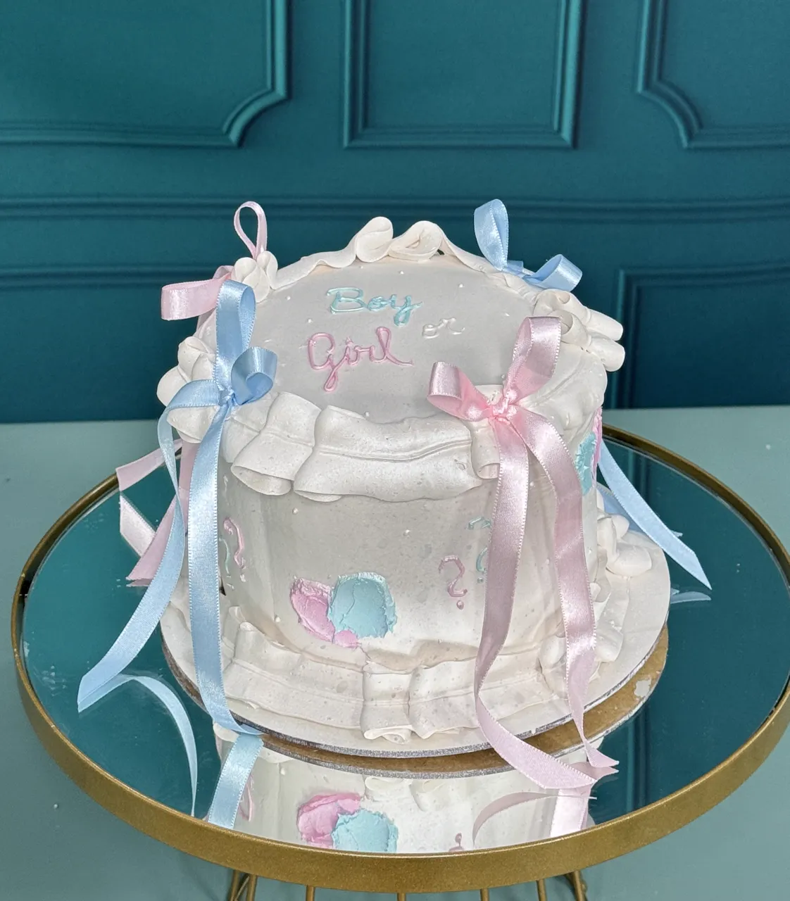 Bolo de chá revelação em tons pastel com figuras de bebê e balões azuis e rosas